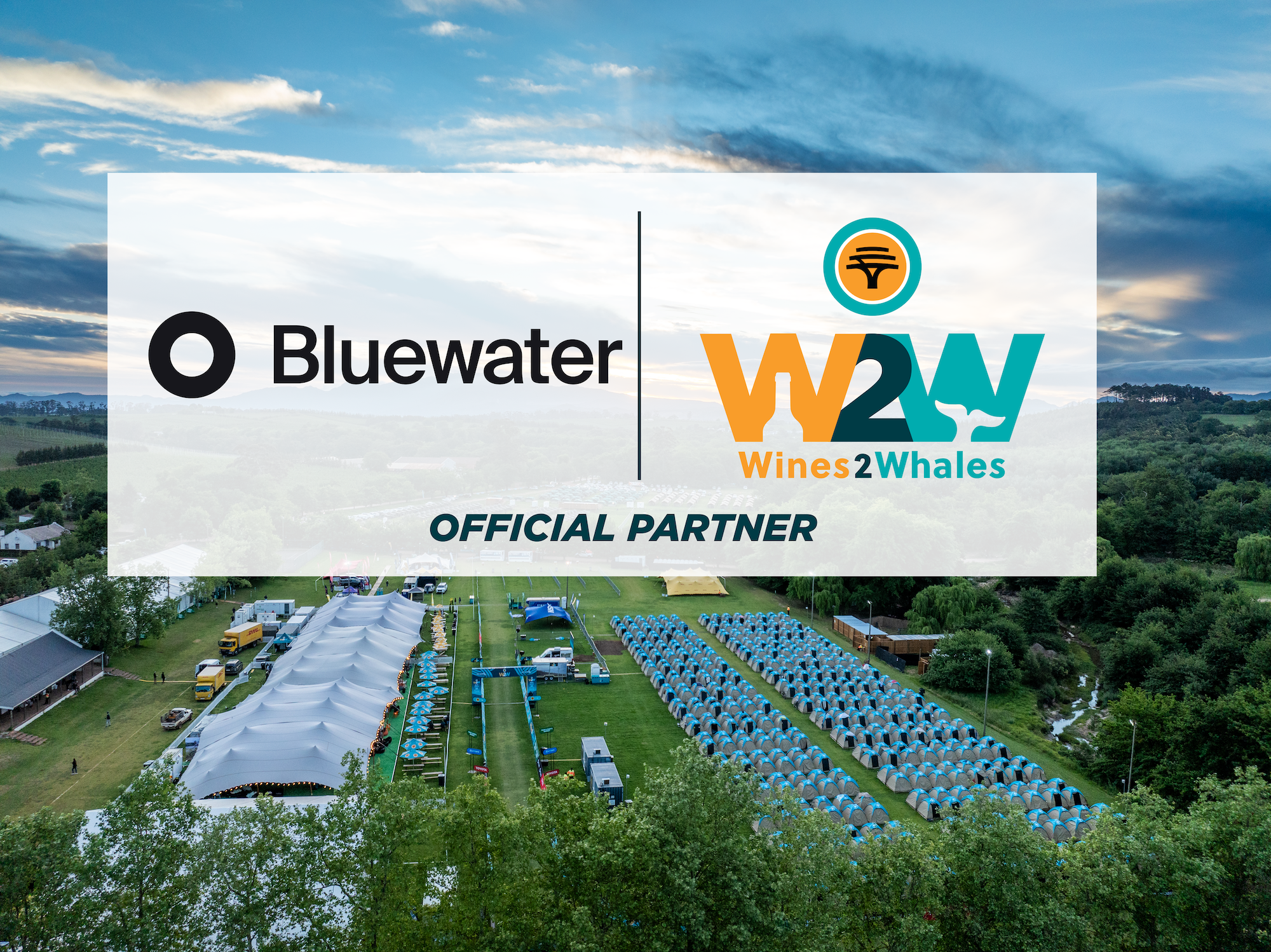 Bluewater and FNB Wines2Whales official-partner graphic over an aerial photograph of the race village.